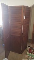 Three-panel wooden room divider with louvers, each panel 18 inches wide, total width 54 inches, height 68 inches, shown partially open with visible scratches.