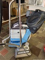 Overview of Econoco Steam Butler steam cleaner unit with wand and accessories alongside SilverStar carpet cleaning machine