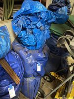Folded blue inflatable bounce house pieces and tarp piled together