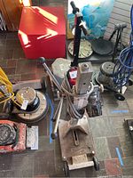 Overview of Milwaukee drill stand next to various floor machines