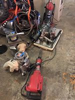 View of the full lot including Porter Cable model 505 sander (red), Chelmsford Planer rotary sanders with cloth dust bags (gray/silver), along with additional power tools and electric saw.