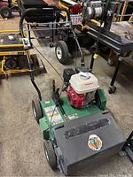 Front perspective of the overseeder showing engine, frame and handlebar