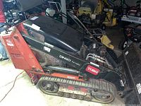 Side view of loader showing left track, loader arms and bucket