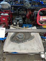 Metal impeller housing component from power rake, placed on a white cloth bag