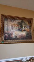 Framed art print depicting a garden scene with flowers, stone urns, and archways in a gold-tone ornate wood frame.
