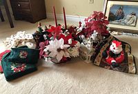 Overview of lot items showing floral centerpieces, green towels, fabric Santa, ceramic church, and Wisemen figurines.