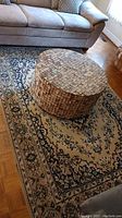 Rug under sofa and round woven coffee table showing full pattern and condition
