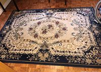Full view of rectangular floral rug placed on parquet floor, showing the overall design and colors.