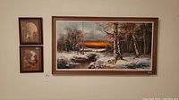 Photo showing all three framed art pieces on wall: one large horizontal oil painting and two small oval-matted prints