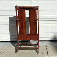 Front view of the Italian mid century suit butler made of hardwood, showing the tray top, pant hanger, and bottom support bar.