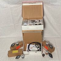 Complete view of the airbrush units with black rubber bulbs assembled and boxed parts including painted labels and a long hose cable.