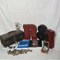 Overall lot display showing tackle box, coins, books, letters, mug, lighters, and compass box on white backdrop