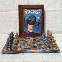 Front view of Stratego board game wooden case with soldier artwork, stone chessboard with chess pieces arranged on board