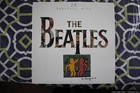 Front cover of the vinyl LP showing the album title '20 Greatest Hits The Beatles' with distinct Keith Haring artwork.