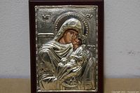 Front view of the silver Byzantine icon mounted on wood showing detailed embossed Virgin Mary and Child Jesus with Greek letters