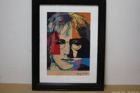 Framed portrait of John Lennon in pop art style by Andy Warhol on wall