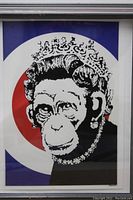 Frontal view of framed print depicting monkey queen with red, white and blue target background