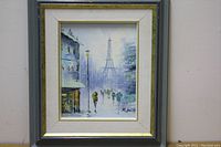 Full view of the framed oil painting showing a misty street scene with the Eiffel Tower and multiple cyclists