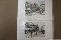 Two framed Paris prints stacked vertically showing street scenes including the Moulin Rouge and Paris architecture.