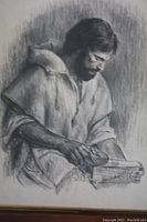 Close-up of framed monochrome portrait drawing showing man in detailed shading holding a book, artist signed.