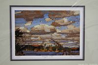 Framed art print depicting a lake scene with trees and a cloudy sky, signed and numbered by the artist Tom Tomson.