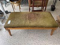 Full top view of rectangular bench upholstered in leopard print hide fabric with gold painted wooden frame.
