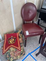 Photo showing the red faux leather side chair, floral tapestry throw pillows, and the Harry Potter Gryffindor themed wall hanging.