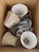 Collection of 5 chandelier lamp shades with fabric and beaded styles, some wrapped in plastic, packed in a cardboard box