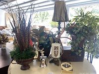 Overview of the lot showing mirror, faux greenery, lamp, candle, bible, bell, and box