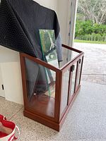 Side angle view of the custom made display cabinet showing wooden frame and glass shelves.
