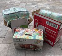 Photo of the lot showing two packages of diapers: one unopened box of Honest Company size 1 diapers and one partially opened pack in a Huggies shipping box.