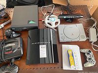 Overview of table showing PS3, PS1, Sega Genesis, VHS VCR, Kinect sensor bar, Wii wheel and controllers