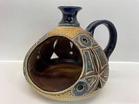 Front view of ceramic art-piece showing open hollow center and decorative etched design.
