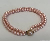 Full view of two-strand pink pearl necklace showing overall design