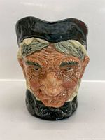 Front view showing detailed, wrinkled elderly woman face with bonnet in black glaze and beige hair highlights