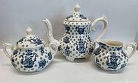 Three Royal Staffordshire ceramic pieces: teapot, sugar bowl, creamer jug in blue and white pattern.