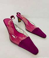 Pair of ladies slingback heeled shoes in pink suede with clear sides and block heels, shown from angle