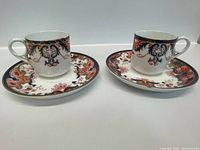 Pair of Royal Crown Derby tea cups and saucers showing overall matching Imari decoration.