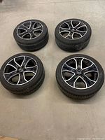 Overview of all four tires mounted on rims laid flat on floor