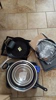 Overview of all items including mixing bowls nested inside each other, frying pans and baking sheets