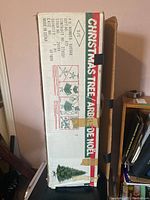Photo of original cardboard box packaging with Christmas tree branding and assembly instructions.