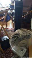 Photo showing Sunbeam tower fan, Super desk fan, and Airworks heater together on floor.