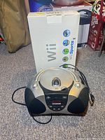 Nintendo Wii Sports boxed console and Durabrand CD radio with wires attached on carpeted floor