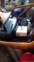 Panasonic portable stereo CD system, boxed item, and black glass plate stand on a brown chair.