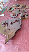 Three wooden plaques shaped as Africa with raised animal figures and one plaque with a clock