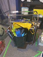 Photo showing the front view of the chrome metal towel rack filled with colorful reusable shopping bags including yellow, black, and blue bags.