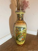 Front-angle photo of the tall Asian style vase showing detailed floral and bird decorations on its body.