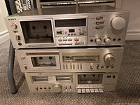 Front view of the three stereo cassette decks stacked showing Sony TC-K65 on top, a silver unit with cassette compartment and various controls.