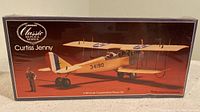 Box front showing Curtiss Jenny biplane model kit in 1/48 scale with pilot figure illustration.