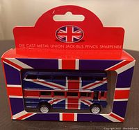 Front of retail box showing die cast metal Union Jack bus pencil sharpener inside clear window